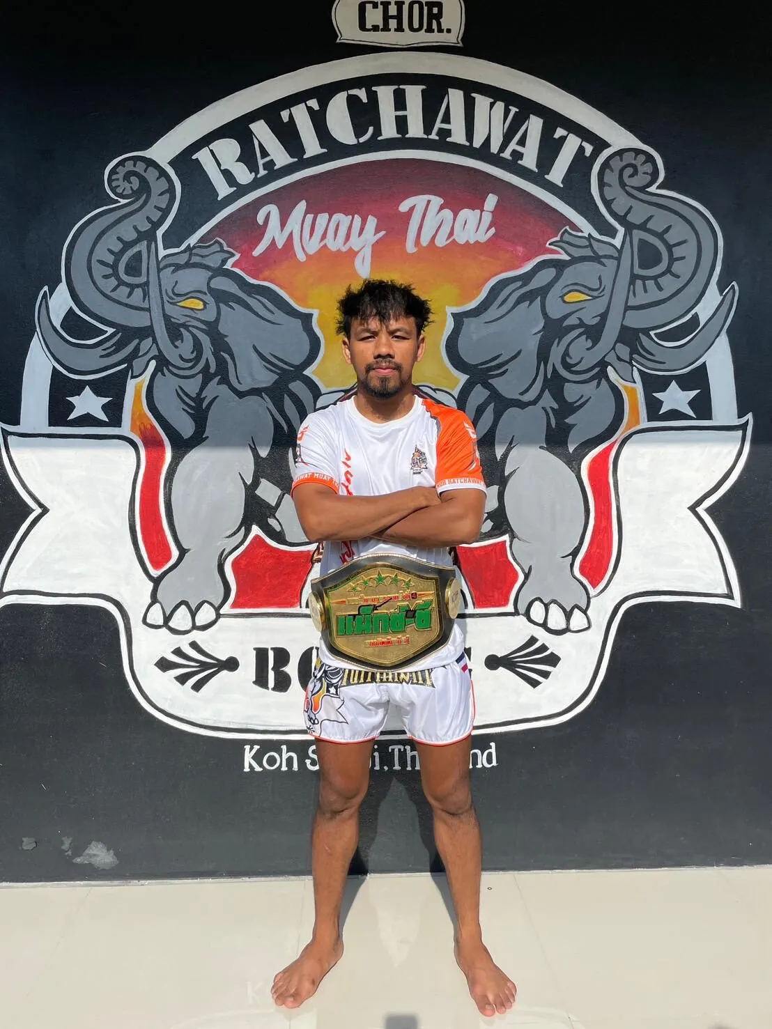 Former Muay Thai champion holding his title belt at the Bophut camp