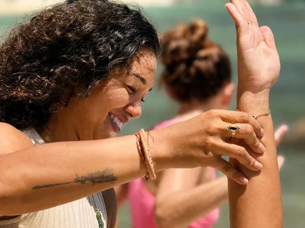 Professeure de yoga ajustant la posture d'une élève — session privée Koh Samui